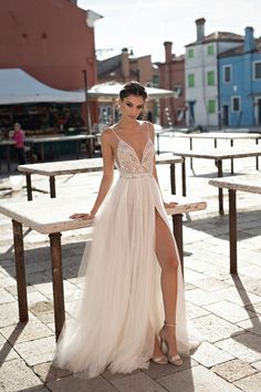 a woman in a white dress posing on a bench