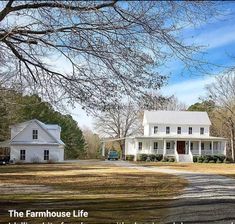 a large white house sitting on top of a lush green field