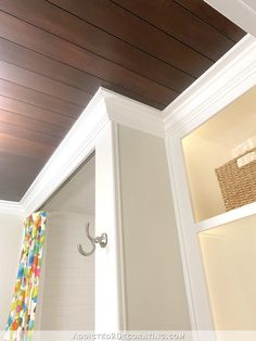 a bathroom with a wooden ceiling and white walls