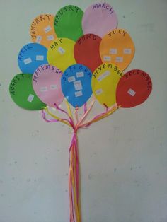 a bunch of colorful paper fan shaped like a tree with writing on it's leaves