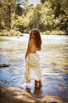 a woman in a white dress is standing in the water