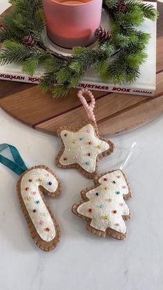 three decorated cookies sitting on top of a table next to a cup and saucer