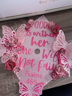 a graduation cap decorated with pink flowers and butterflies that says god is my son, one who not fail