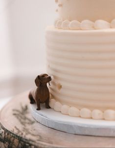 a dog figurine sitting on top of a white cake