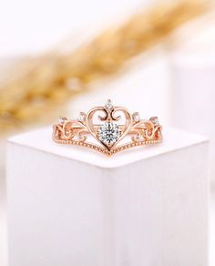 a close up of a ring on top of a white box with gold and diamonds