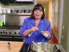 a woman pouring something into a pot on the stove