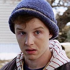 a young man wearing a blue hat and scarf