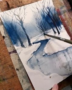 someone is painting a snowy scene with watercolors