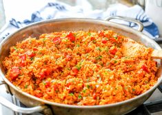 a pan filled with rice and vegetables on top of a stove