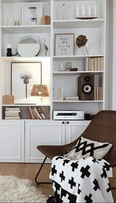 a living room filled with lots of white bookshelves covered in pictures and decor