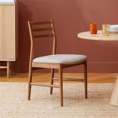 a wooden chair sitting in front of a table with plates and cups on top of it