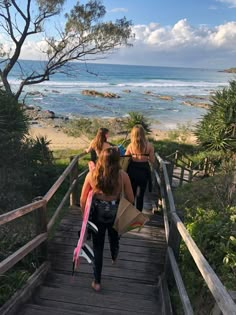 three women walking up stairs towards the beach