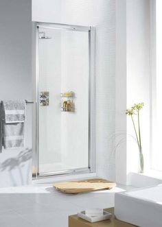 a white bathroom with a glass shower door