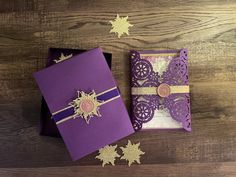 two purple and gold cards on a wooden table