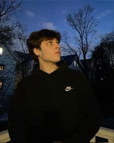 a young man standing in front of a window