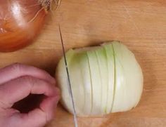 a person cutting an onion with a knife