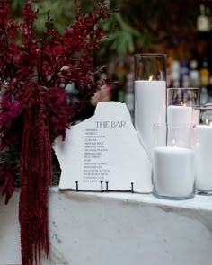 candles and flowers are sitting on a table with the name of the event written on it