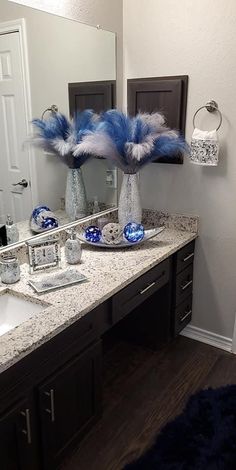 a bathroom vanity with two blue and white vases on top of the countertop