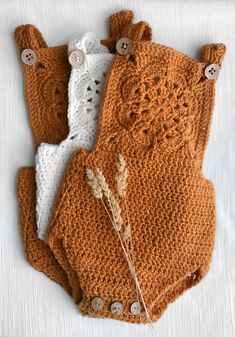 three crocheted items are laid out on a white tablecloth, one is brown and the other is white