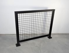 a black and white fence sitting on top of a cement floor