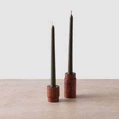 two tall candles sitting on top of each other