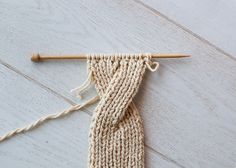 a close up of a knitted piece of cloth with a knitting needle on it