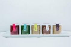 five different colored bags with the word love spelled out in them on a white tray