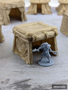 a miniature figurine is standing in front of a table with drapes on it