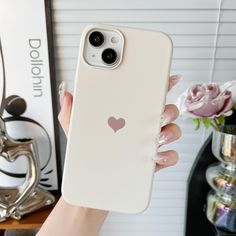 a woman is holding up her phone case with a heart on the front and side