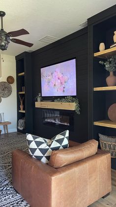 a living room filled with furniture and a flat screen tv mounted on the wall above a fireplace