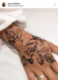 a woman's hand with a flower tattoo on it