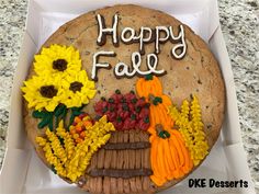 a decorated cookie in a box with flowers and leaves on it that says happy fall