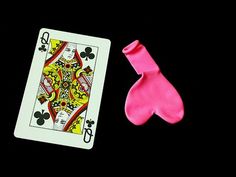 a pair of pink socks next to a playing card on a black background with the ace symbol