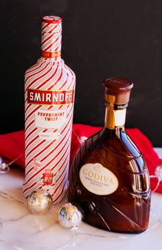 a bottle of vodka next to an ornament with candy canes on the table