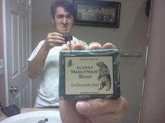 a man taking a selfie in front of a bathroom mirror with a soap bar