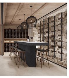 a bar with stools and wine bottles on the wall behind it in an industrial style kitchen