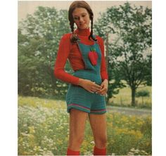 a woman in overalls and red boots posing for the camera with her hands on her hips