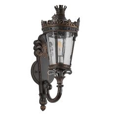 an old fashioned wall light with a crown on it's top and two lights attached to the side