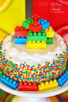 a birthday cake decorated with legos and sprinkles on a white plate