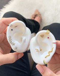 two white ear plugs with different designs on them in the palm of someone's hand