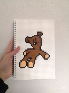 a hand holding a notebook with an image of a teddy bear on it