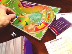 a person playing a board game on a table next to some cards and papers with dices