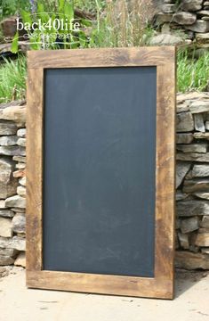 a blackboard sitting in front of a stone wall