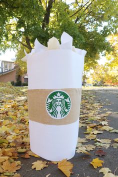 a starbucks cup sitting in the middle of leaves