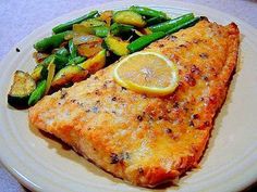 a white plate topped with fish and vegetables