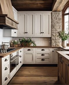 a kitchen with white cabinets and wood floors, an oven and sink are in front of the window