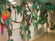 an office decorated with paper leaves and parrots on the branches, along with other decorations