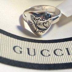 New With Tags. Gucci Box, Pouch & Papers. Gucci Ring. Band Ring In Sterling Silver. Graphic Engraved With Symbolic Gucci Motifs. Heart Shaped Face. The Front Features Eye, Heart And The Phrase Blind For Love. Bird And Flowers Adorn The Back. Size 7.5. Designer Silver Heart-shaped Jewelry, Designer Silver Heart Jewelry, Gucci Sterling Silver Jewelry For Gift, Gucci Silver Jewelry Gift, Gucci Silver Ring With Polished Finish, Gucci Sterling Silver Ring For Formal Occasions, Gucci Rings With Polished Finish For Gift, Luxury Sterling Silver Heart Cut Ring, Luxury Heart-shaped Ring