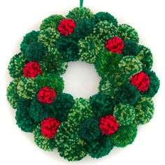 a green wreath with red flowers on it