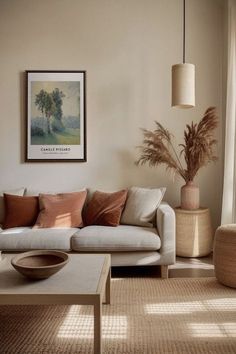 a living room filled with furniture and a painting hanging on the wall above it's windows